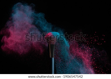 Blue and pink makeup on a powder brush hit in a mixed cloud