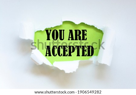 YOU ARE ACCEPTED appearing behind torn paper. Business