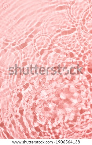 Transparent and clean pink water background with sunlight reflection, top view