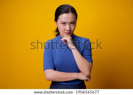 Asian woman standing and angry isolated over yellow background. Royalty-Free Stock Photo #1906565677