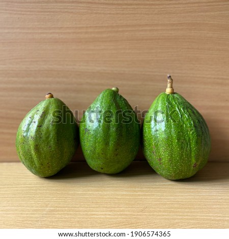 A line of avocado (Persea americana) on table. This smooth textured fruit is well known for its healthy fats, common for vegetarian or diet food.