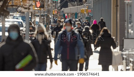 Anonymous blurred crowd of people walking street wearing masks