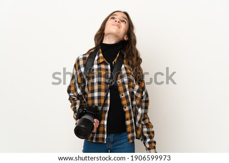 Little photographer girl isolated on background and looking up