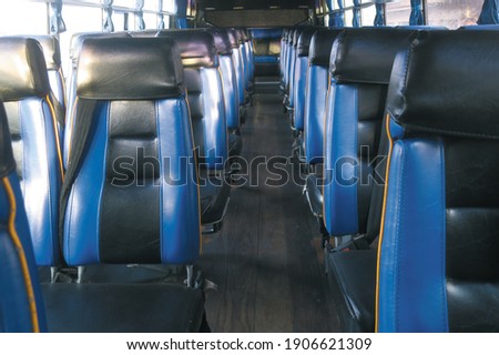Inside view with a lot of bus blue multi seat in a row and vintage wooden floor