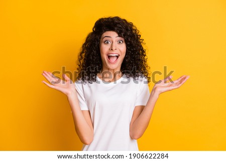 Photo portrait of amazed surprised girl happy cheerful gesturing hands isolated on vibrant yellow color background