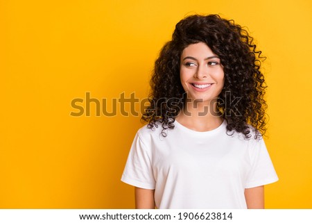 Photo of young attractive beautiful smiling cheerful positive girl in white t-shirt look copyspace isolated on yellow color background
