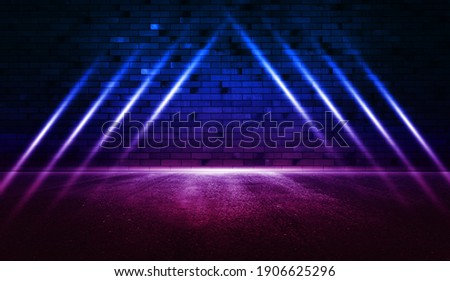 Rays neon light on neon brick wall with wet asphalt. Empty scene. Copy space