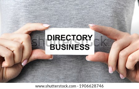 The girl holds a business card with the text DIRECTORY BUSINESS.