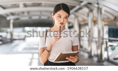 Young adult business working asian woman using digital portable tablet for online application. City people lifestyle with modern technology. Background with copy space on day.
