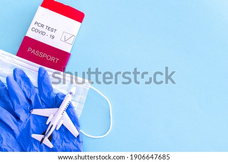 passport with ticket with pcr test for covid with medical mask gloves on isolated blue background theme of travel to pandemic Royalty-Free Stock Photo #1906647685