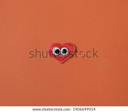 Red heart with funny  toy eyes , copy space, Romance, love and enjoy and have fun in the holidays concept