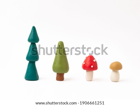 plasticine trees and mushrooms  on a white background. children's crafts made of plasticine