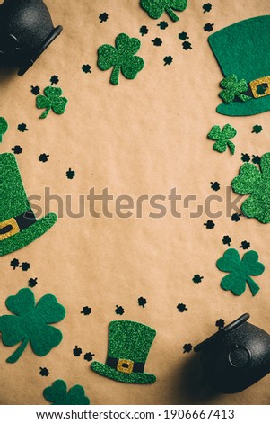 Happy St Patrick's Day concept.  Flat lay leprechaun hats, clover shamrock leaves, pots of gold on kraft paper background. Vertical banner template for social media stories. Vintage, retro style.