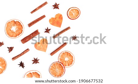 Dried orange slices (chips), cinnamon sticks, star anise and cut paper hearts are on a white background. Healthy meal snack. Colorful background for Valentine's Day. Top view. Flat lay. Copy space.