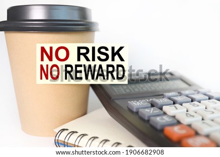 no risk, no reward, text on yellow sticker. sticker pasted on a cup of coffee on a white background. business concept. calculator. notebook
