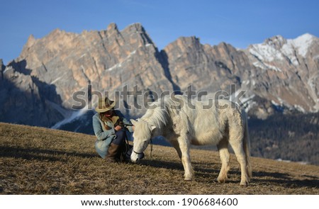 the woman with the white horse with in the background mount Cristallo in Cortina D'Ampezzo
