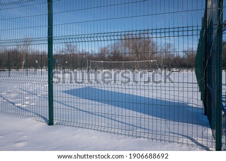 playground behind a green fence, winter