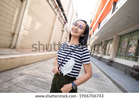 Portrait Asian woman wear striped t-shirt hang cloth mask with strap anti lost or forgotten for protective for spreading of disease Covid-19