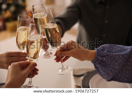 People clinking glasses with champagne at home, closeup Royalty-Free Stock Photo #1906727257