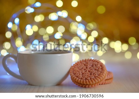white cup, golden bokeh and cheerful mood,cookies