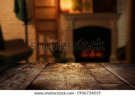 Empty wooden surface and blurred view of fireplace in room