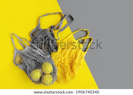 Reusable shopping bags with lemons. Colors of the year 2021 Ultimate Grey and Illuminating. Color trend palette. Stylish background
