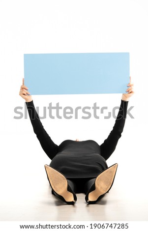 Office woman lying on floor and holding a blank board, isolated on white.