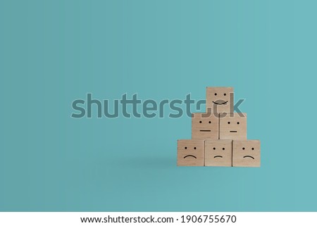 Smile face and cart icon on wood cube. Optimistic person or people feeling inside and service rating when shopping, satisfaction concept in business.