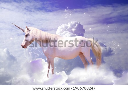Magic unicorn in fantastic starry sky with fluffy clouds Royalty-Free Stock Photo #1906788247