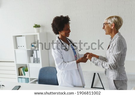 Woman doctor supporting elderly female patient