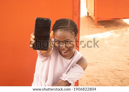 an african lady holding her phone