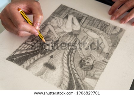 Close-up of hands making a figurative drawing in black and white. Artist working in her studio