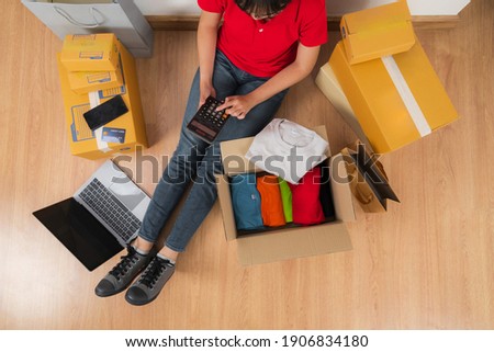 Asian woman working with calculator, Selling online ideas concept, Online seller business shop at home 