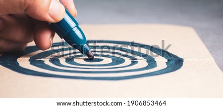 Closeup hand drawing target with pen on the notebook, concept for business marketing, goal, setting, career objective Royalty-Free Stock Photo #1906853464