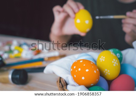 Happy easter daughter painting Easter eggs. Happy holiday preparing for Easter. painting colorful eggs for Easter hunt getting ready for celebration on wooden table