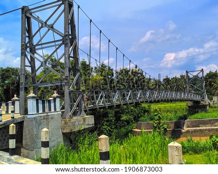 iron suspension bridge into a beautiful background scenery