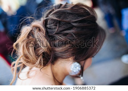 The beauty of a wedding hairstyle. Bride. A brunette brown-haired with curly hair.Hair decoration. large earrings. balayage on the hair, a bunch of hair
