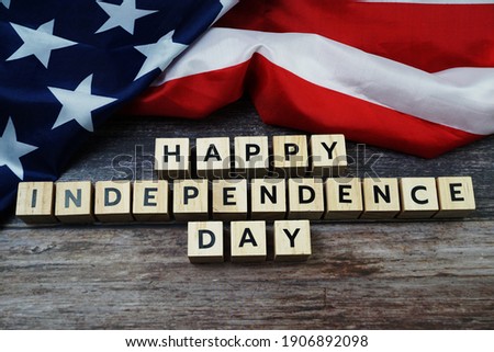 Happy Independence Day Word alphabet letters with USA flag on wooden background