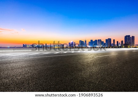 Empty asphalt road and modern city skyline in Hangzhou at sunrise,China.