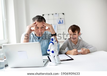 Annoyed father with kid working from home during quarantine. 