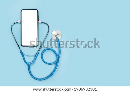 online doctor. app health phone mockup. get an online consultation from doctor by mobile phone. stethoscope and cell phone on blue background. copy space. doctor online consultation concept Royalty-Free Stock Photo #1906932301