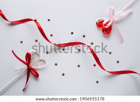 Valentine's day flat lay photography with sweet heart shape lollipops. Romantic greeting card background.