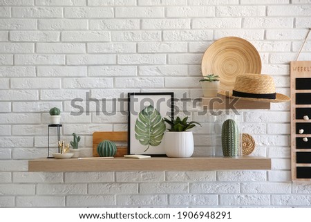 Shelves with decorative elements on white brick wall. Interior design