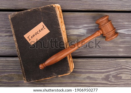 Innocent trial verdict concept. Top view book and judge gavel.