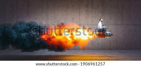 man sitting on a rocket with flames and smoke. concept of success and determination. Royalty-Free Stock Photo #1906961257