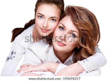 Mother and Teen Daughter. Close-up portrait of attractive happy mother and smiling teenage daughter isolated on a white background. Teenager girl with her mom