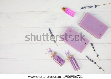 Body care set, lavender soap, lavender scrub and lavender oil on a white wooden background. Body treatment, skin care concept. Flat lay.