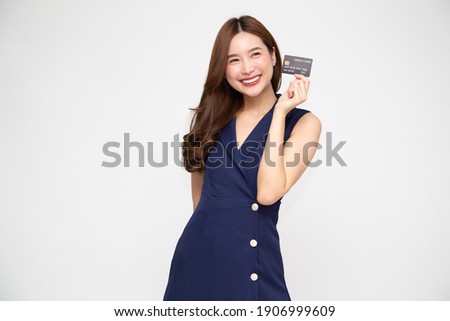 Young beautiful Asian woman smiling, showing, presenting credit card for making payment or paying online business, Pay a merchant or as a cash advance for goods, Cardholder or A person who owns a card Royalty-Free Stock Photo #1906999609
