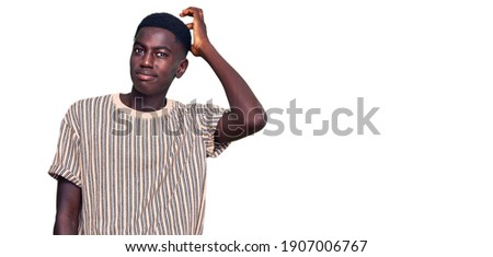 Young african american man wearing casual clothes doing ok gesture like binoculars sticking tongue out, eyes looking through fingers. crazy expression. 