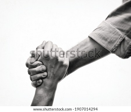 A human's hand saving the another human. Black and white image. Concept of salvation, donorship, helping hand. Royalty-Free Stock Photo #1907014294